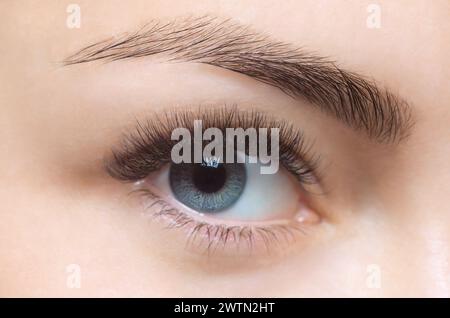 Eyelash removal procedure close up. Beautiful Woman with long lashes in a beauty salon. Look at the camera. Stock Photo