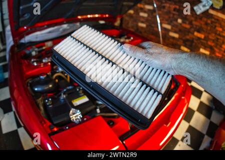 Changing a dirty engine air filter. Stock Photo