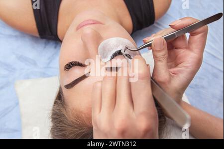 Eyelash removal procedure close up. Beautiful Woman with long lashes in a beauty salon. Eyelash extension. Stock Photo