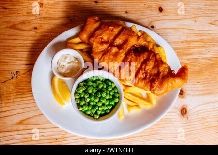 Fish and chips is a hot dish consisting of fried fish in batter, served with chips and peas. Cowes,Isle of Wight, England, United Kingdom, Europe Stock Photo
