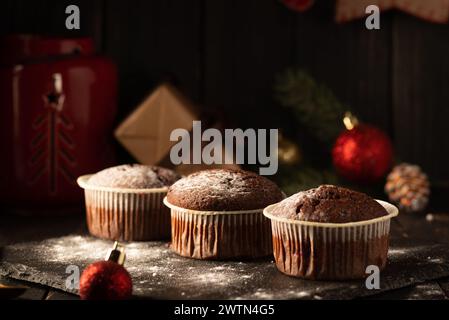 chocolate muffins with powdered sugar on top on a black background. Christmas decoration . Still life close up. Food photo Stock Photo