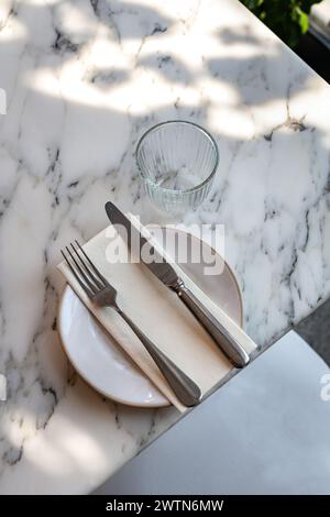 Luxury table setting on marble table with side plate and dappled shadow light Stock Photo