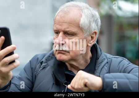 Senior man looking confused at mobile phone. Stock Photo
