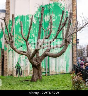 Banksy Tree artwork and street art at Christie Court, Hornsey Road, Hornsey, Islington, London. Painted green wall to represent leaves on a bear tree. Stock Photo