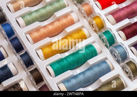 Colorful threads and plastic bobbins for sewing machines Stock Photo