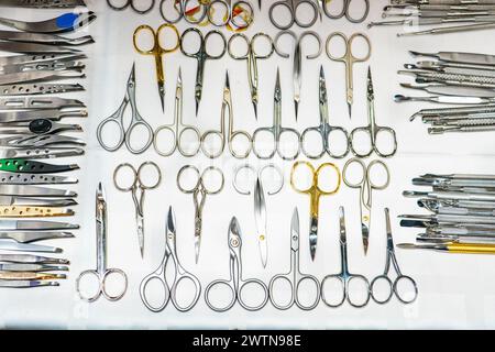 Set of many different scissors for manicure. Metal scissors on a white background. Close-up.. Stock Photo