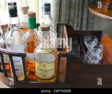 Whisky bottles and glasses in home bar. Stock Photo