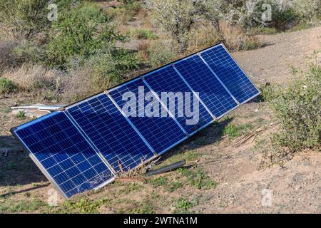 Photovoltaic solar panels on the ground on a makeshift frame in the wild.  Concept for Solar being available anywhere the sun shines. Stock Photo
