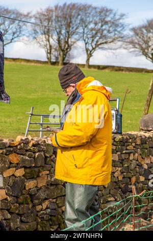Craftsman repairing a drystone wall in the Derbyshire English Peak District Stock Photo
