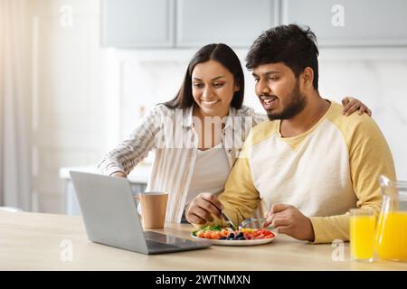 Happy eastern spouses planning vacation while have breakfast Stock Photo