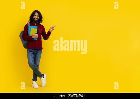 Cheerful young indian man student pointing at copy space Stock Photo