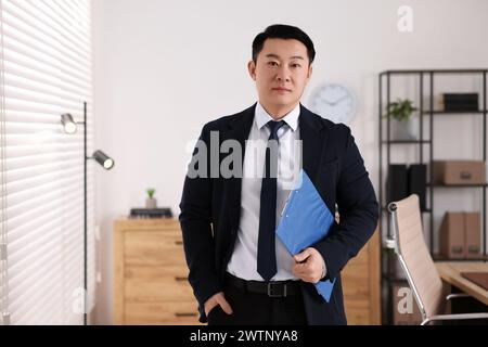 Portrait of confident notary with clipboard in office Stock Photo