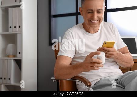 Middle-aged man checking pills description online at home Stock Photo