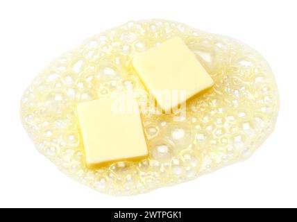 Two pieces of butter melting isolated on white background Stock Photo