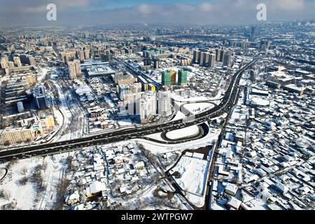 Aerial drone view panorama of Alfarabi avenue with car traffic and big buildings skyscraper at winter in Almaty city,  Kazakhstan Stock Photo