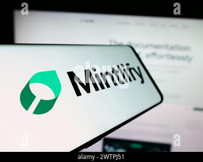 Mobile phone with logo of American documentation platform company Mintlify Inc. in front of website. Focus on center-left of phone display. Stock Photo