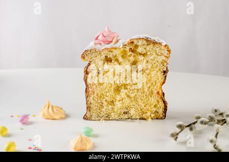 Place setting for Easter dinner on the white table with Easter cake with colorful topping, Decorative chocolate eggs sweets, willow and holiday decora Stock Photo