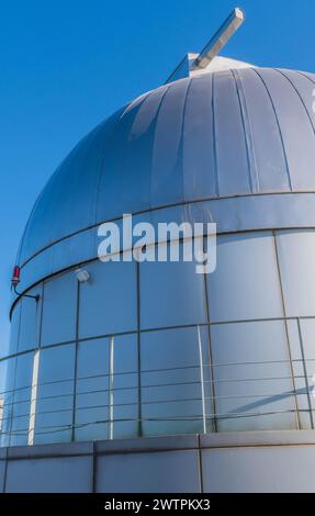 A metallic dome of an observatory with a cross on top against a clear blue sky, in South Korea Stock Photo