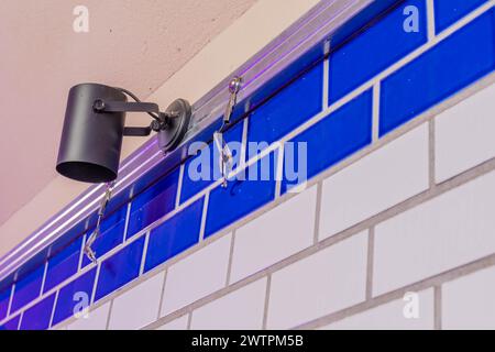 A modern spotlight mounted on a tiled wall with blue and white tiles, in Daejeon, South Korea Stock Photo