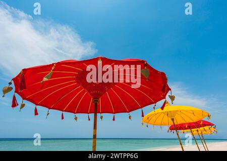 Traditional Balinese temple sunshade as parasol, Hinduism, symbol, beach holiday, protection, sun protection, Balinese, culture, red, yellow, sun Stock Photo