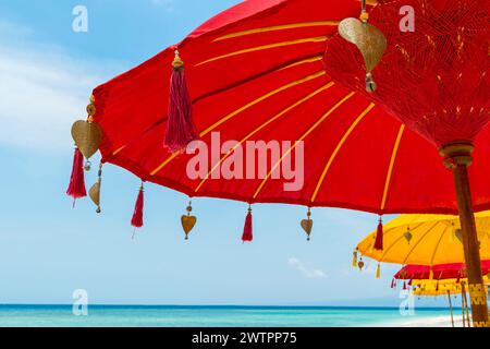 Traditional Balinese temple sunshade as parasol, Hinduism, symbol, beach holiday, protection, sun protection, Balinese, culture, red, yellow, sun Stock Photo