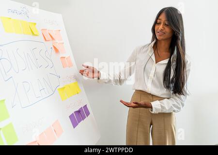 Young Businesswoman explaining charts in conference room at white board - Business seminar planning meeting Stock Photo