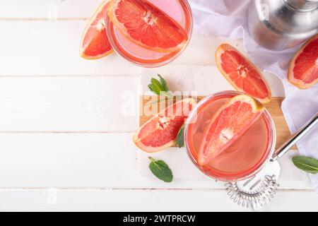 Grapefruit martini cocktail with cold champagne. Refreshing summer cocktail with garnish of a piece of grapefruit and mint on a light background with Stock Photo