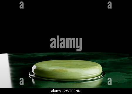 Green podium for showcasing products. pedestal in emerald, striking contrast with dark backdrop. Its polished surface is designed to draw attention to Stock Photo
