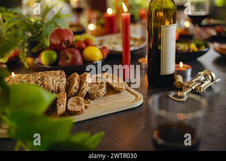 Healthy multi grain cut bread with seeds on a wooden board is standing on festive table Stock Photo
