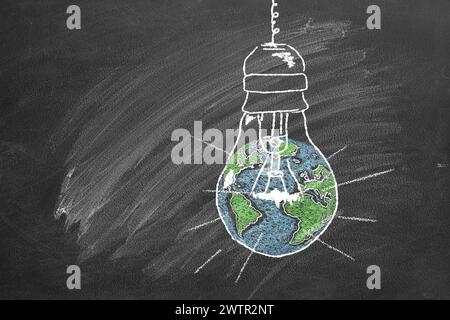A light bulb with a globe inside, drawn in chalk on a school chalkboard. Earth hour concept. Save the world. Save our planet. Stock Photo