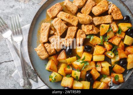 Rojoes Portuguese dish of fried pork cubes and potatoes closeup on the plate on the table. Horizontal top view from above Stock Photo