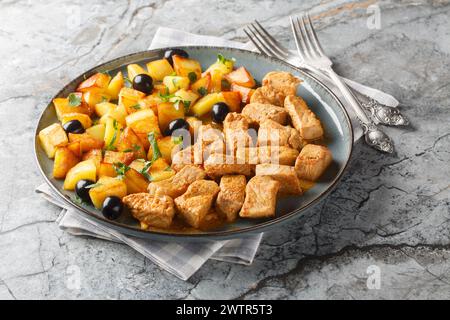Rojoes Minhota made of boneless pork which are marinated in white wine, garlic and cumin and then fried and stewed closeup on the plate on the table. Stock Photo