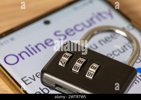 A combination padlock on top of a smartphone with the words online security. An online security concept. Stock Photo