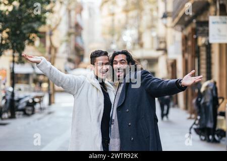 Happy gay couple smiling and making funny face while posing outdoors in the street. Stock Photo
