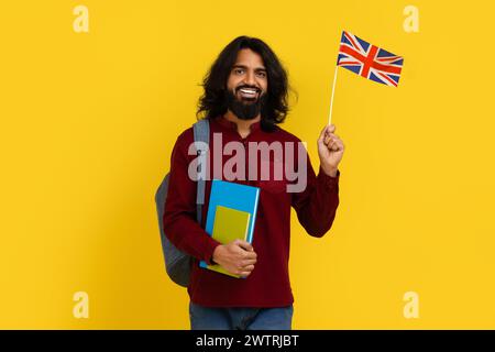Smiling indian guy student showing flag of Great Britain Stock Photo