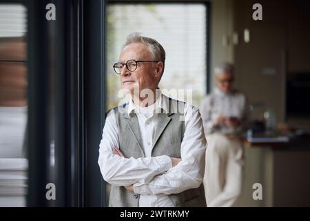 Senior man at home looking out of window Stock Photo