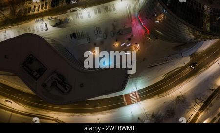 Drone photography of decorated christmas trees in a city between buildings during winter cloudy night Stock Photo