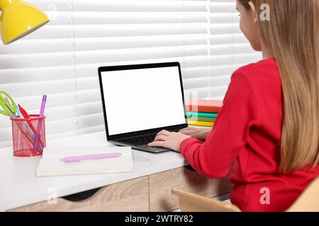 E-learning. Girl using laptop during online lesson at table indoors, closeup Stock Photo
