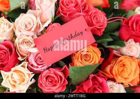 Bouquet of beautiful roses with Happy Birthday card, top view Stock Photo