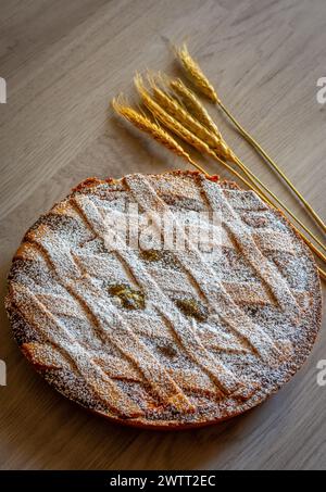 Neapolitan Pastiera Crostata, typical italian cake for Easter time exposed with ears of wheat. Filled with ricotta cheese and candied fruit. Stock Photo