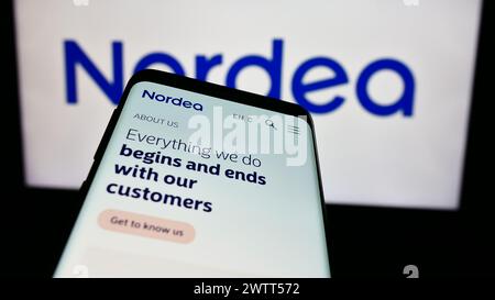 Smartphone with website of Finnish financial services company Nordea Bank Abp in front of business logo. Focus on top-left of phone display. Stock Photo