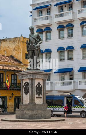 Cartagena, Colombia - July 25, 2023: Pedri de Heredia monument, bronze sculpture on stone pedestal on Plaza de los Coches. Police van in back in front Stock Photo