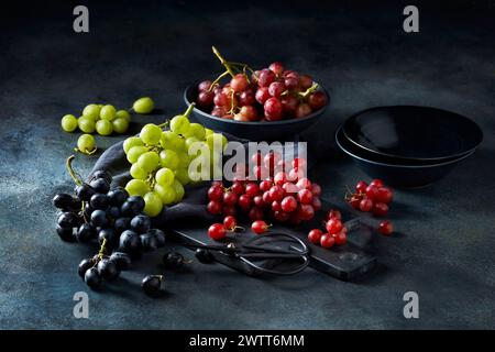Assorted fresh grapes on rustic kitchen table Stock Photo