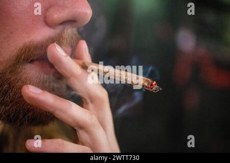Closeup of a person smoking a rolled cigarette Stock Photo
