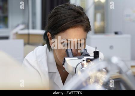 Attractive female scientist testing using microscope to test for dna Stock Photo