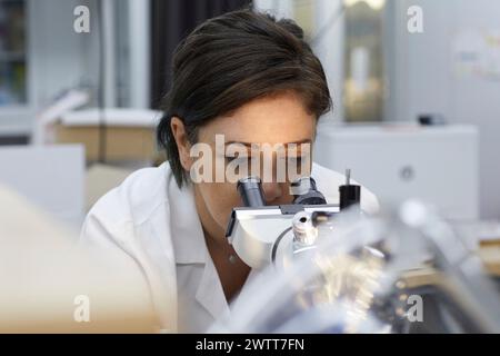 Attractive female scientist testing using microscope to test for dna Stock Photo