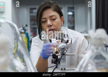 Attractive female scientist testing using microscope to test for dna Stock Photo