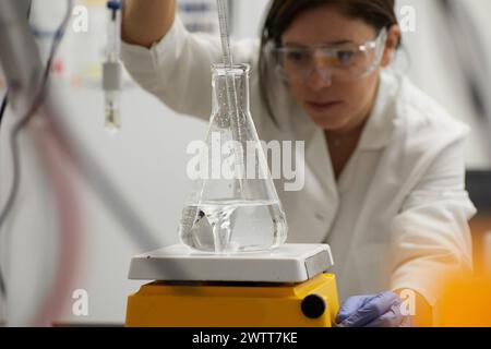 Attractive female scientist testing using beaker and peppet in labratory Stock Photo