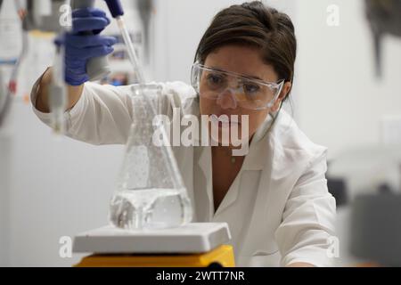 Attractive female scientist testing using beaker and peppet in labratory Stock Photo