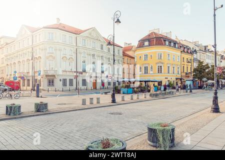 Evening glow on a quaint European street bustling with life. Stock Photo